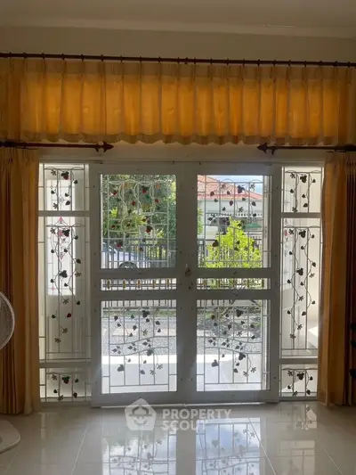 Charming living room with decorative window grills and warm curtains, offering a cozy ambiance.