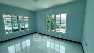 Spacious empty room with large windows and tiled floor, offering ample natural light and a view of neighboring houses.