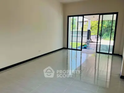 Spacious living room with large sliding glass doors leading to a lush garden view.