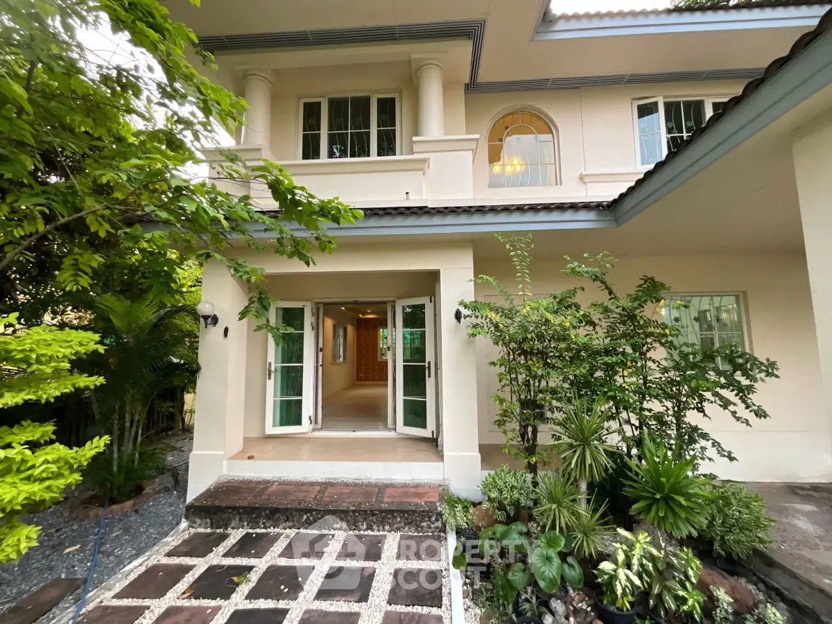 Elegant two-story house with lush garden and inviting entrance