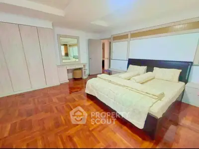 Spacious bedroom with elegant wooden flooring and modern furnishings