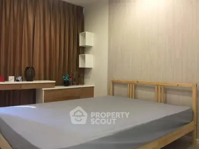 Cozy bedroom with wooden bed frame and modern decor in a stylish apartment.