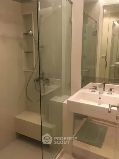 Modern bathroom with glass shower and sleek fixtures in a contemporary home.