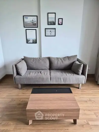 Modern living room with stylish gray sofa and wooden coffee table on elegant wooden flooring.