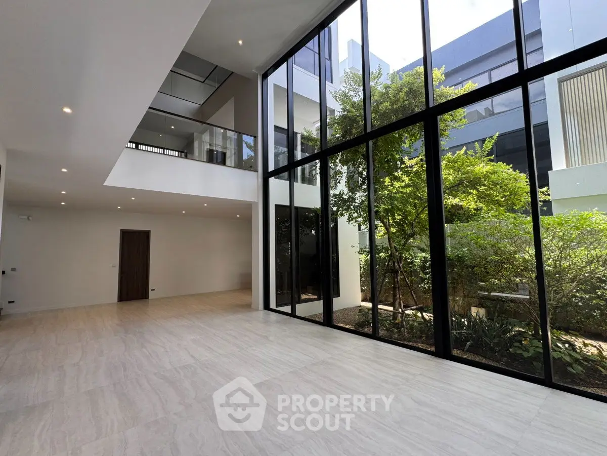 Spacious modern living room with floor-to-ceiling windows and garden view