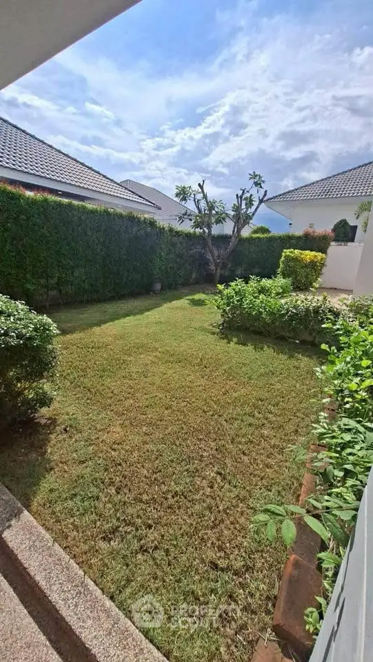 Charming garden view with lush greenery and clear skies, perfect for outdoor relaxation.