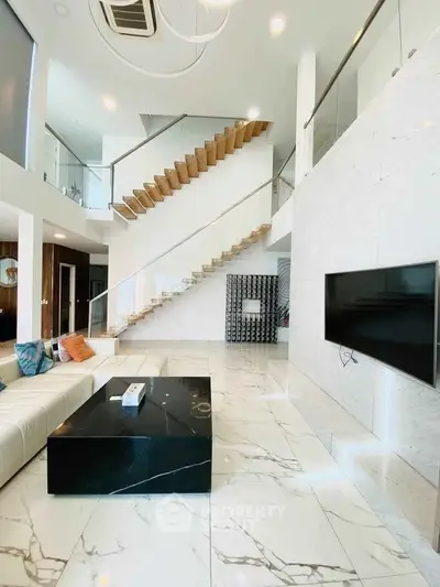 Luxurious modern living room with marble floors and floating staircase