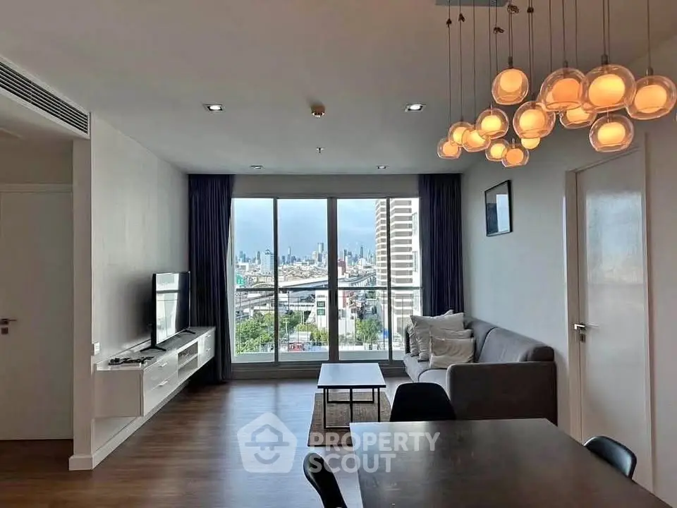 Modern living room with city view, stylish lighting, and cozy seating area.