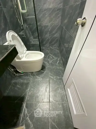 Modern bathroom with sleek black marble tiles and contemporary fixtures.