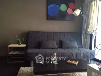 Modern living room with stylish sofa, abstract art, and natural light from large window.