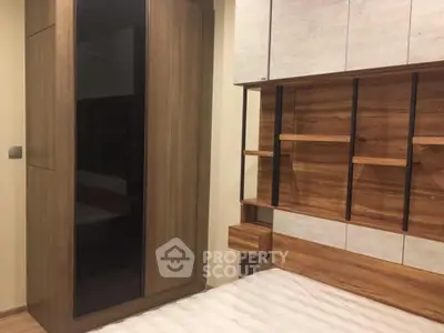 Modern bedroom with stylish wooden furniture and built-in storage solutions.