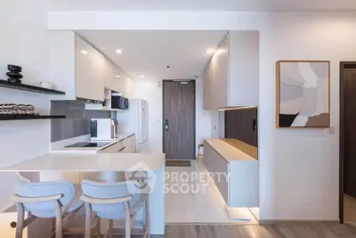 Modern kitchen with sleek design, open layout, and stylish bar seating in a contemporary apartment.
