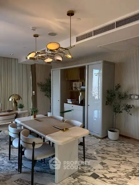 Luxurious dining area with elegant marble table and modern lighting in upscale apartment.