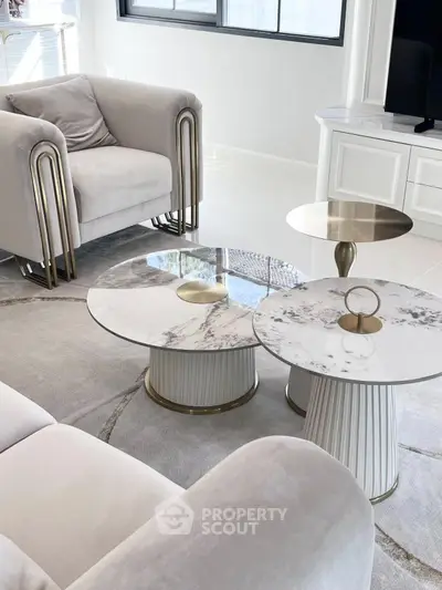 Elegant modern living room with plush seating and marble coffee tables.