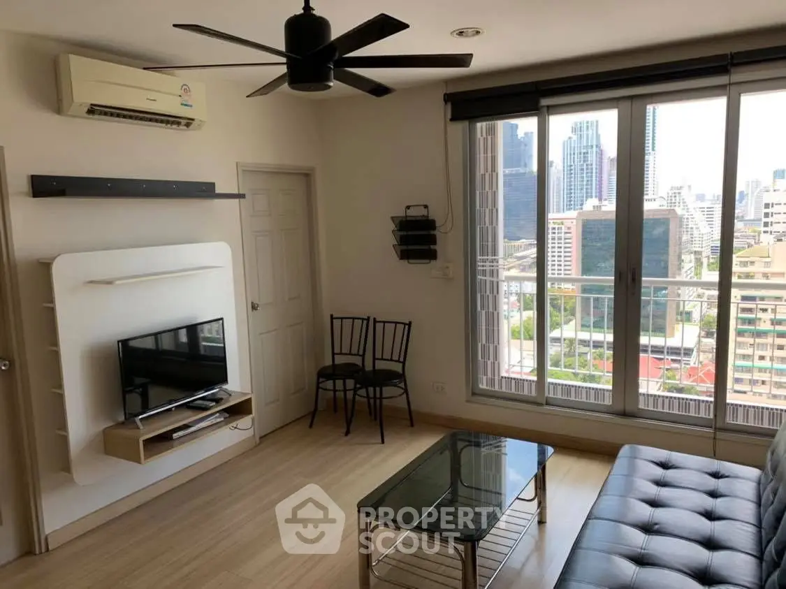 Modern living room with city view, sleek furniture, and large windows for natural light.