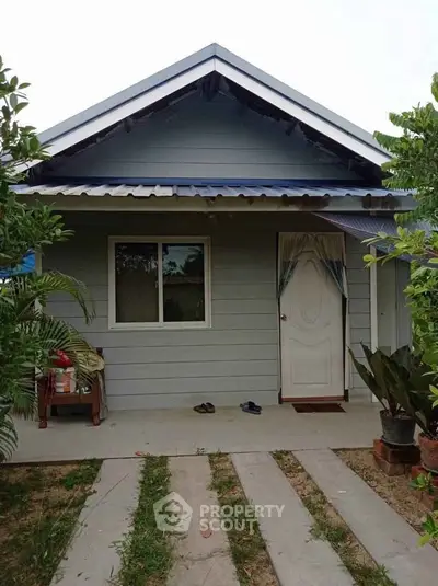 Charming single-story home with inviting entrance and lush greenery