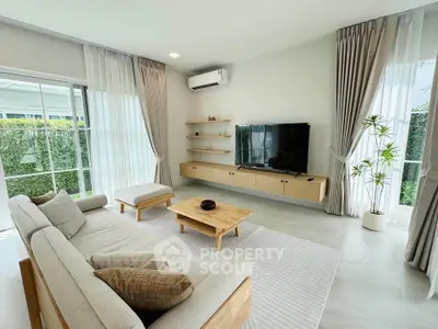 Modern living room with stylish furniture and large windows offering natural light and garden view.