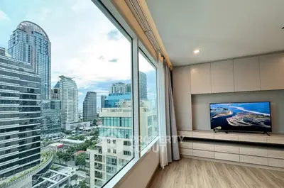 Modern living room with stunning city view through large windows, featuring sleek built-in entertainment unit.