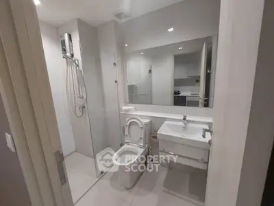 Modern bathroom with glass shower and sleek fixtures in contemporary apartment.