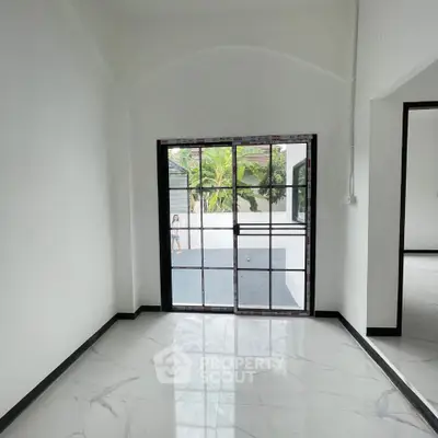 Spacious modern interior with large glass doors and sleek marble flooring.