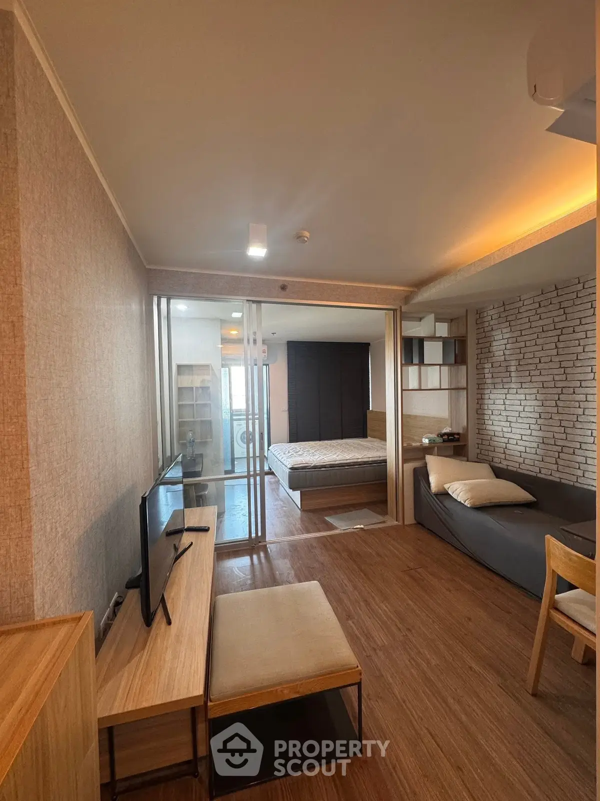 Modern studio apartment with open layout and stylish decor, featuring a cozy living area and a comfortable bed.