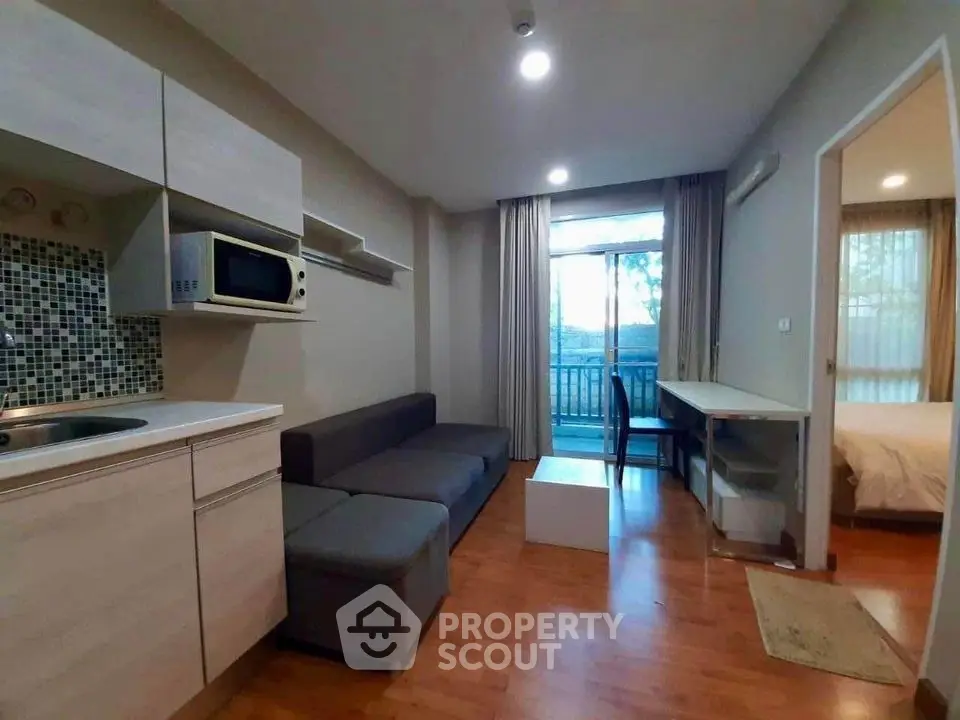 Modern apartment living room with kitchenette and balcony view