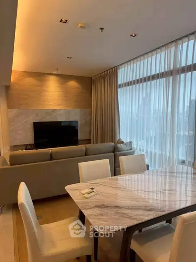 Luxurious modern living room with elegant dining area and large windows offering stunning city views.