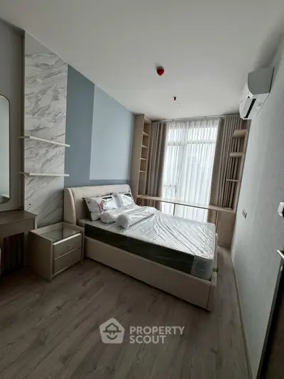 Modern bedroom with stylish decor and natural light, featuring a comfortable bed and elegant furnishings.