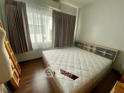 Cozy bedroom with large window and modern decor in a bright apartment.