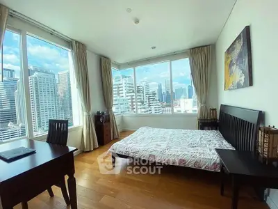 Spacious bedroom with stunning city view and modern furnishings in high-rise apartment.