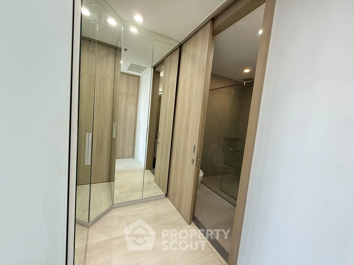 Modern bathroom with sleek mirrored cabinets and wooden accents