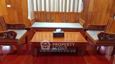 Elegant wooden living room set with intricate carvings and polished finish.