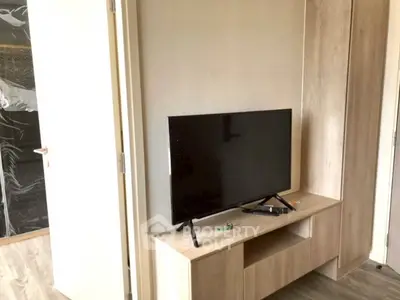 Modern living room with sleek TV setup and wooden cabinetry