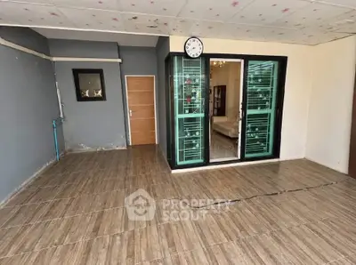 Spacious tiled room with glass doors leading to a cozy living area, ideal for modern living.
