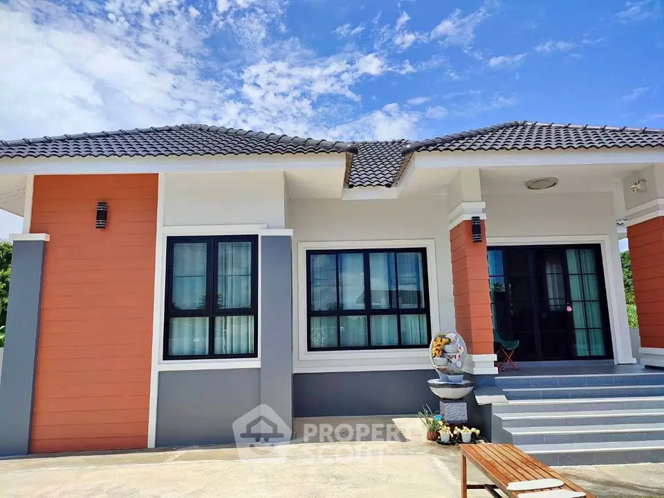 Charming single-story home with modern facade and inviting entrance under a clear blue sky.