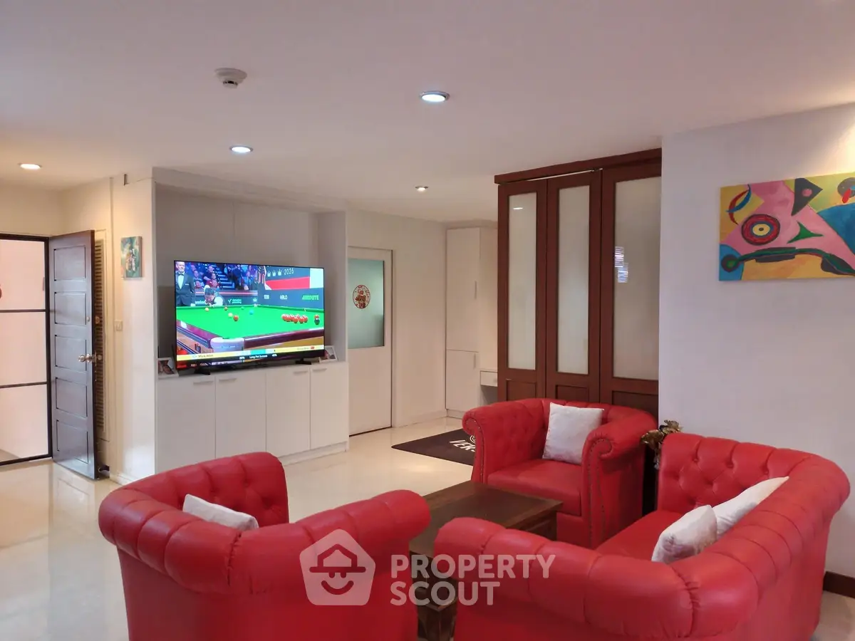 Spacious living room with vibrant red sofas and modern decor