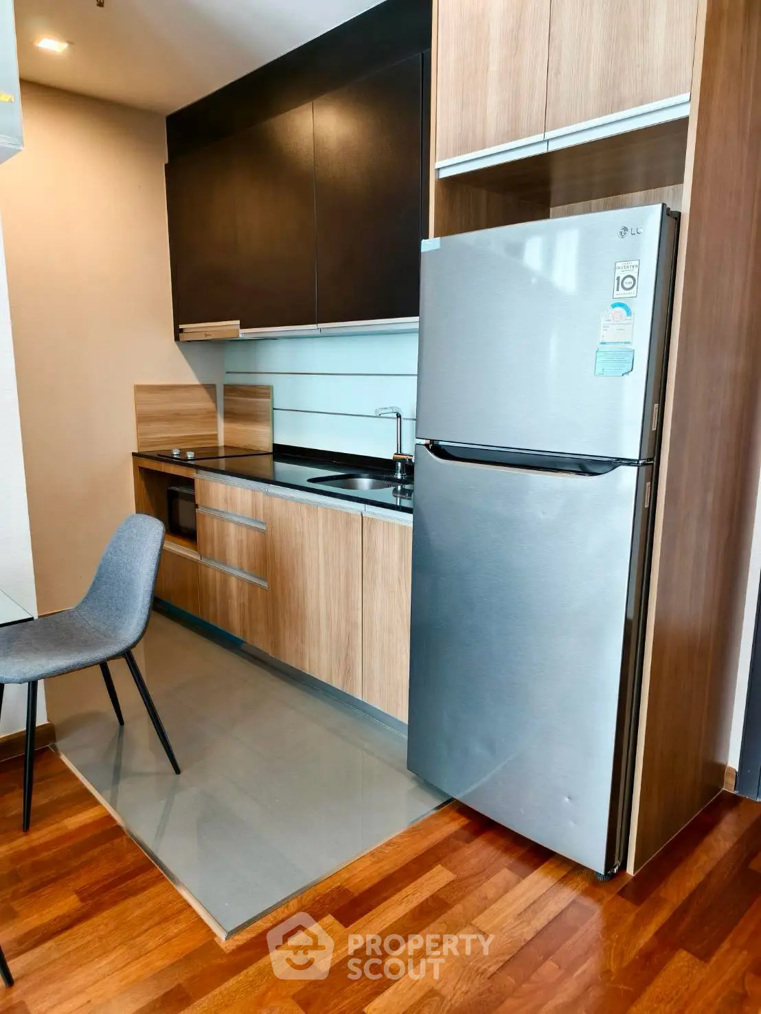 Modern kitchen with sleek cabinetry and stainless steel fridge in a stylish apartment.