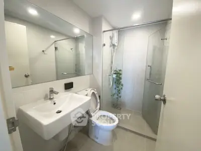 Modern bathroom with glass shower and sleek fixtures in a contemporary home.
