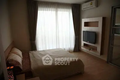 Modern bedroom with large window, air conditioning, and wall-mounted TV in a cozy apartment.