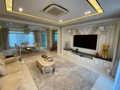 Luxurious living room with modern decor and spacious layout, featuring elegant furniture and large TV.