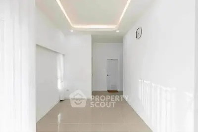 Spacious minimalist living room with modern ceiling design and natural light