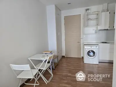 Compact studio apartment with kitchenette and washing machine, ideal for urban living.