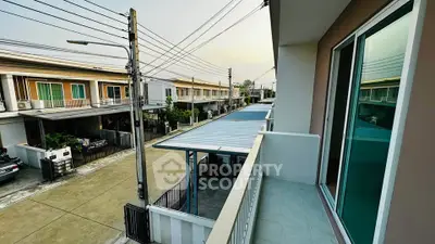 Modern townhouse with balcony overlooking a quiet residential street, showcasing contemporary design and spacious layout.