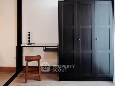 Modern study area with sleek black wardrobe and minimalist desk