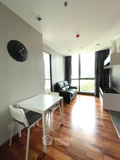 Modern living room with wooden flooring and large window view