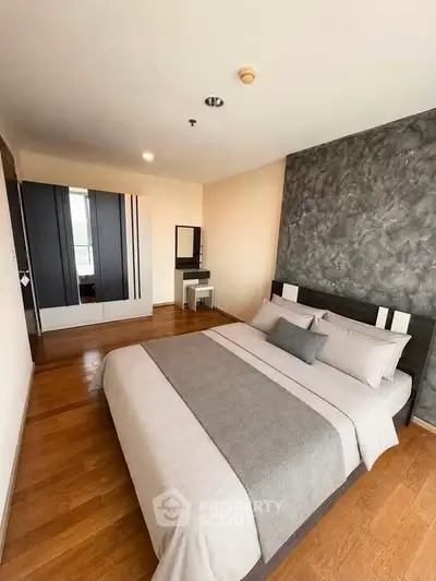 Modern bedroom with stylish decor and wooden flooring in a contemporary apartment.