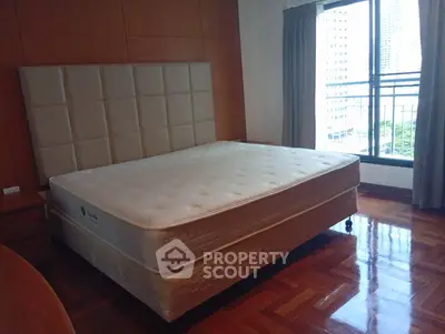 Spacious bedroom with large bed and city view from window