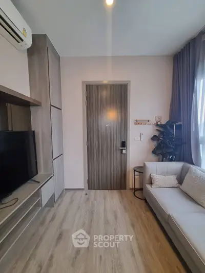 Modern living room with sleek design, featuring a cozy sofa, TV, and stylish wooden flooring.