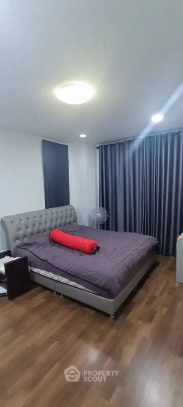 Spacious bedroom with modern decor and wooden flooring