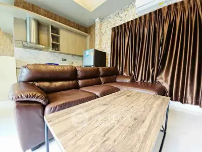 Luxurious living room with brown leather sofa and modern kitchen in open layout design.